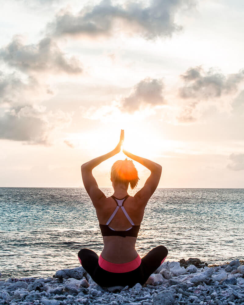 Practicing yoga at one of the stunning beaches during my bonaire adventures while watching the sunset